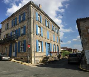 モンパジエにあるLa Maison Anglaiseの青い艶戸のある古いレンガ造りの建物