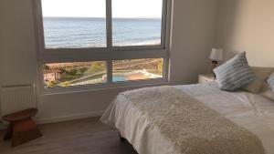 um quarto com uma cama e vista para o oceano em Punta Puyai - Departamento Nuevo primera línea em Papudo