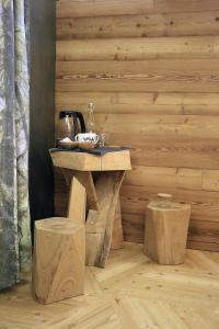 a wooden table and two stools in a room at One room in Sauze dʼOulx