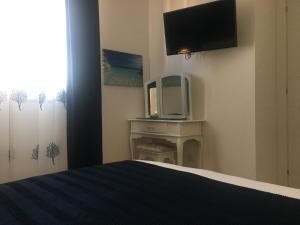 a hotel room with a bed and a tv at Blue Sea Rooms Apartment Cagliari in Cagliari