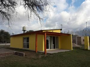 a small yellow house with a large window at Departamento Teodelina in Quehué