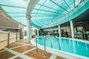 een zwembad in een gebouw met een glazen plafond bij Muong Thanh Vinh Hotel in Vinh