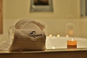 a towel on a table next to a candle and a candle at Ironstone Romantic Couples Retreat in Halls Gap