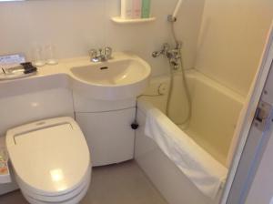 a bathroom with a toilet and a sink and a shower at Kanazawa Manten Hotel Ekimae in Kanazawa