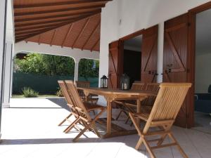 a wooden table and chairs on a patio at Villa les Lataniers St-Francois in Saint-François