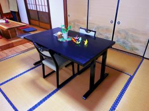 una mesa negra con un tazón de flores. en Guest House Motomiya, en Nakatsugawa