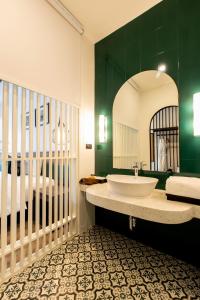 een badkamer met een wastafel, een bed en een spiegel bij Chaanburi Boutique Resort in Chanthaburi