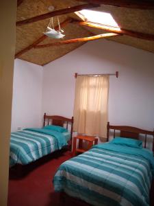 a bedroom with two beds and a ceiling at Samana Wasi in Yanque