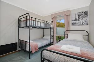 a bedroom with two bunk beds and a window at Abbey Rose - Bright, VIC in Bright