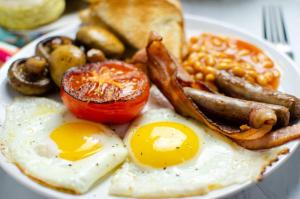 a plate of breakfast food with eggs sausage and toast at Mckala Guesthouse in Kimberley