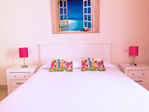 a bedroom with a white bed with two lamps at La Graciosa Punta Caracol in Caleta de Sebo