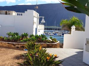 ein weißes Gebäude mit Blick auf einen Yachthafen in der Unterkunft La Graciosa Punta Caracol in Caleta de Sebo
