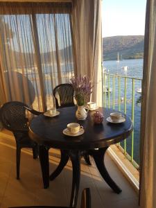 a table with two chairs and a window with a view of the water at Cres view apartments in Cres