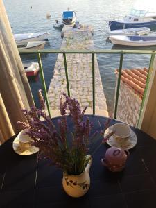 a table with a vase of flowers on top of it at Cres view apartments in Cres