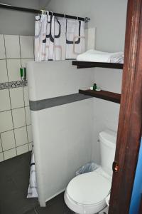 a bathroom with a white toilet and a bed at Hotel "Casa Las Lolas" in Xpujil