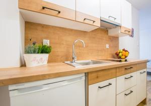 a kitchen with white cabinets and a sink at Central Apartments Goleniow in Gollnow