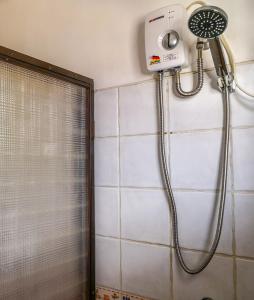 y baño con ducha con cabezal de ducha. en Spinning Cat Hostel, en Tagbilaran City