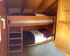 - 2 lits superposés dans une chambre en bois dans l'établissement L'Eau-Vive, à Loèche-les-Bains