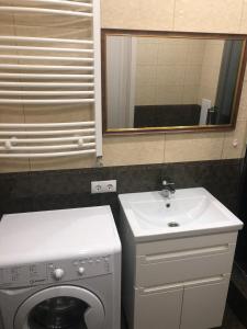 ein Badezimmer mit einer Waschmaschine und einem Waschbecken in der Unterkunft GIL apartments, 38 Prospect Svobody in Uschhorod