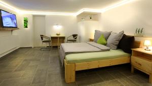 Dormitorio con cama, escritorio y TV en elli's, en Schwabach