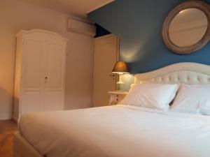 a bedroom with a white bed and a mirror at Cosmopolitan Central Rooms in Bologna