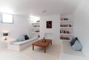 een witte woonkamer met een bank en een tafel bij Lithia Villas in Chora Folegandros