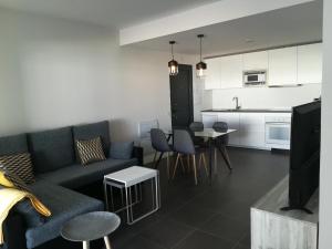 sala de estar con sofá y cocina en Marta & Lorenzo Apartment. Fuerteventura, en La Oliva