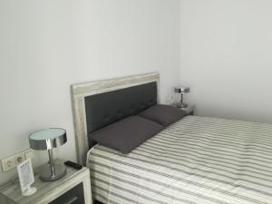 1 dormitorio con 1 cama y 2 lámparas en una mesa en Marta & Lorenzo Apartment. Fuerteventura, en La Oliva
