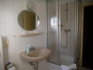 a bathroom with a sink and a shower with a mirror at Pension Redefin in Redefin +24 photos