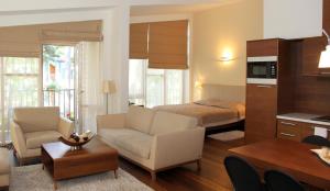 a living room with a bed and a living room with a couch at Jūros Apartamentai in Palanga