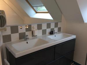 a bathroom with a white sink and a skylight at A l'Orée de Bruz in Pont-Péan