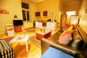 een woonkamer met een leren bank en een tafel bij Urban Nest Apartments Świętego Marka27 in Krakau