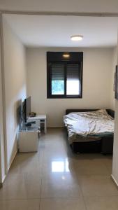 1 dormitorio con 1 cama y TV en 29 Efraim Street Apartment, en Modi'ín