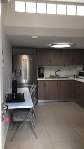 a kitchen with a table and a stainless steel refrigerator at 29 Efraim Street Apartment in Modi'in +8 photos
