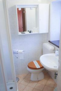 a white bathroom with a toilet and a sink at Indren Hus in Alagna Valsesia