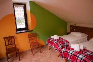 a bedroom with two beds and a green wall at Indren Hus in Alagna Valsesia +18 photos