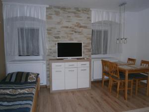 a living room with a tv and a dining room table at Apartmány Brychovi in Červený Potok