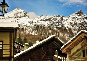 a snow covered mountain in front of a house w obiekcie Indren Hus w mieście Alagna Valsesia