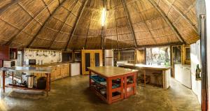 a large kitchen with a large straw roof at Manico Camp in Portinho da Inhaca