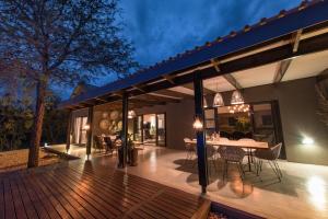 a house with a wooden deck with a dining table at Bushwillow Private Villa in Hoedspruit
