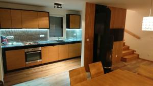 維塔諾瓦的住宿－MiniResort VITA NUOVA，厨房配有木制橱柜和餐桌