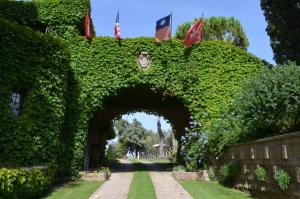 einen Zugang zu einem Garten mit einem Bogen mit Flaggen in der Unterkunft Parco delle Nazioni - Relax Grand Resort in Castel di Decima