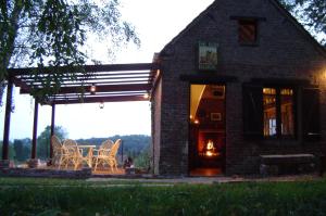 a brick house with a table and chairs and a fireplace at Coury House, Chavasse Farm, Somme in Hardecourt-aux-Bois