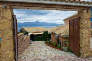 una entrada a una casa con una pared de piedra en Vergina Star Hotel en Nikiana