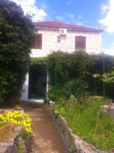 a white house with a garden in front of it at Apartments Skrivaneli in Jelsa