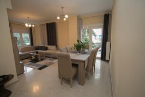 - une salle à manger avec une table, des chaises et un canapé dans l'établissement Athenian Riviera Apartment, à Athènes