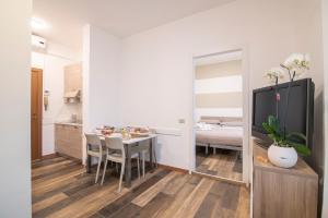 a kitchen and dining room with a table and a television at Residenza Miola in Saronno