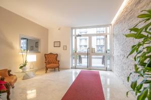 a living room with a chair and a red rug at Residenza Miola in Saronno