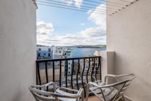 - un balcon avec deux chaises et une vue sur l'eau dans l'établissement Seashells 2 bedroom Apartment with sunny terrace with stunning sea views - by Getawaysmalta, à San Pawl il-Baħar