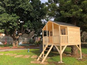 una pequeña casa de juegos de madera en un árbol en Bar-On Vacation Resort - Nature, Culture, Tours & Tastes near Nahariyya - בר-און ריזורט, בתי מפונים , טבע, תרבות, סיורים וקולינריה, en Ben ‘Ammi